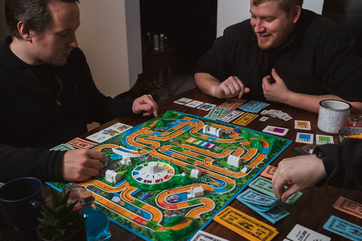 Amigos adultos riendo mientras juegan un juego de mesa, disfrutando del entretenimiento compartido